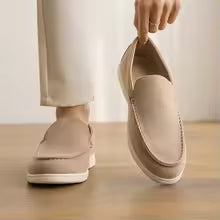 Person wearing beige shoes on a wooden floor with a light-colored wall background