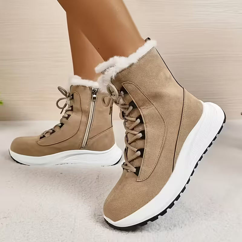 Brown winter boots with white fur lining worn by a person on a light background