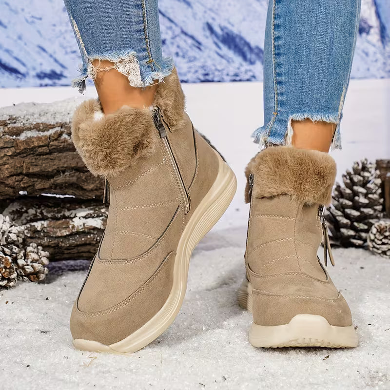 Beige winter boots with fur trim worn in a snowy landscape.