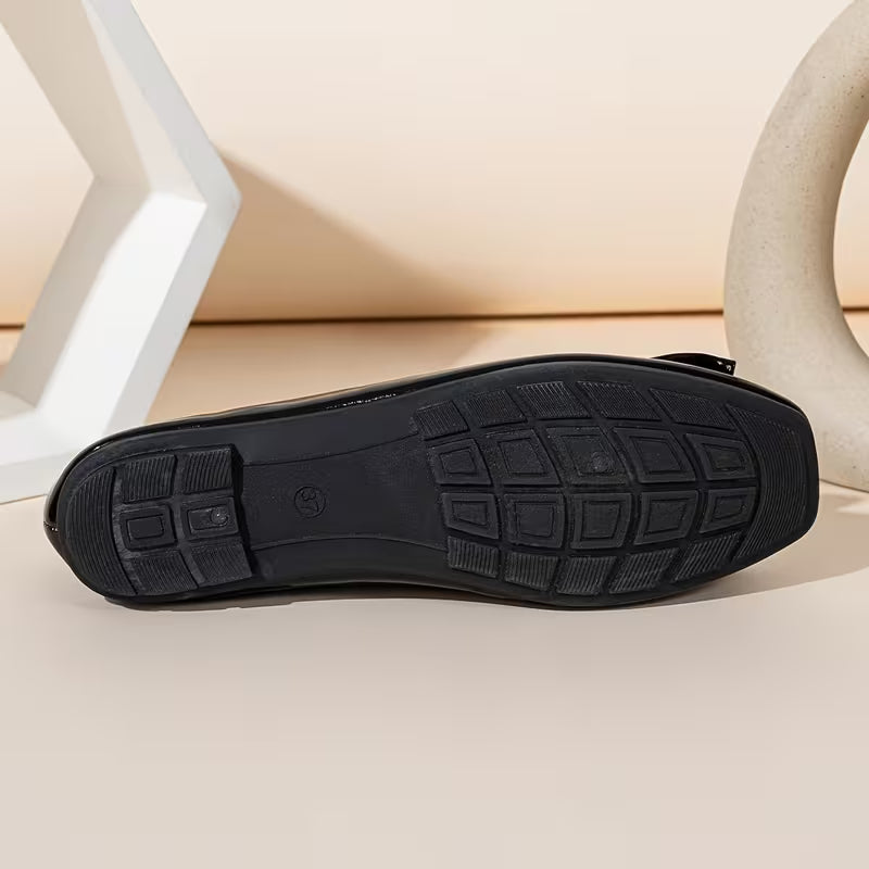 Black shoe sole on a light beige surface with a blurred background