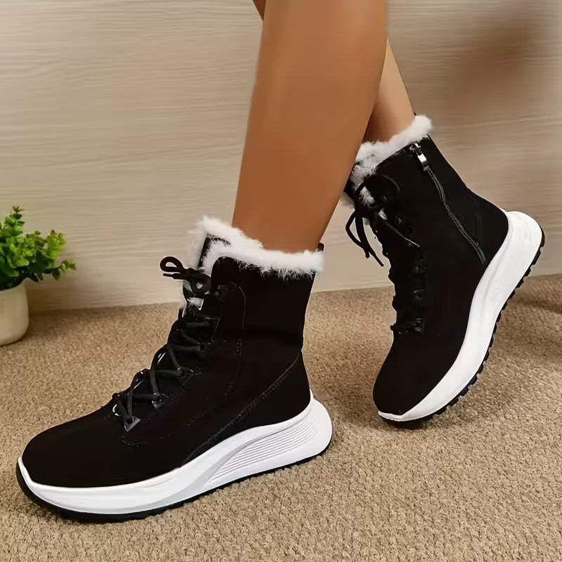 Black winter boots with white soles worn by a person on a beige carpet.