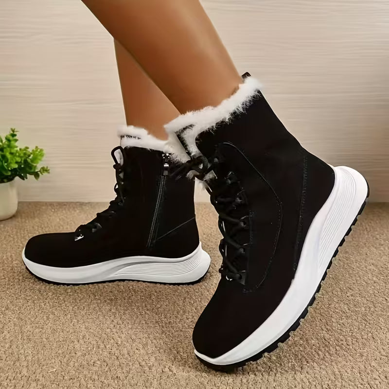 Black winter boots with white soles worn by a person on a carpeted floor.