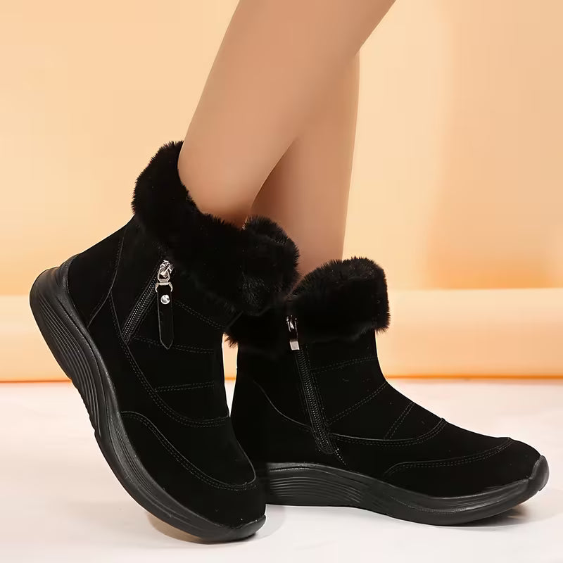 Black winter boots with fur trim on a beige background
