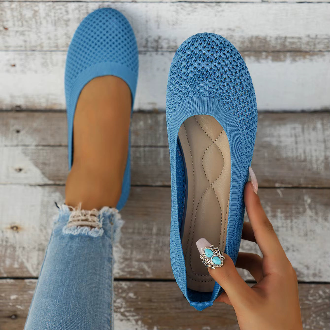 Blue flats being held up against a wooden background