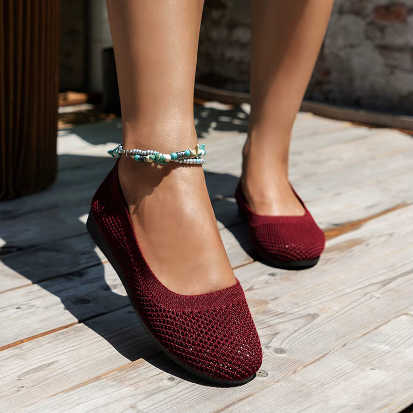 Red textured shoes worn on a wooden floor with a blurred background