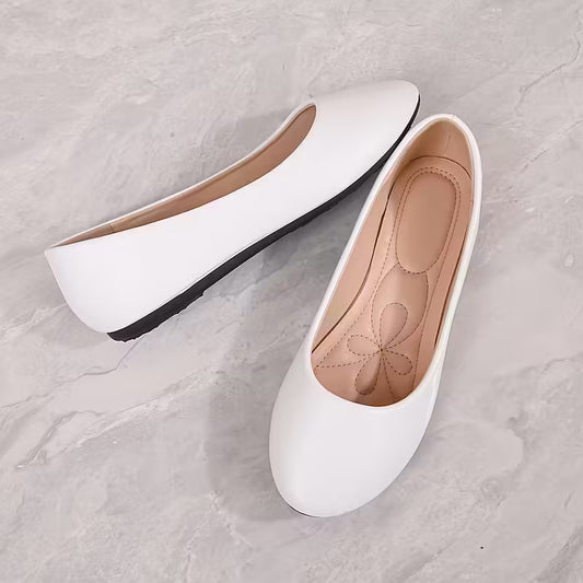 White flat shoes on a gray marble surface